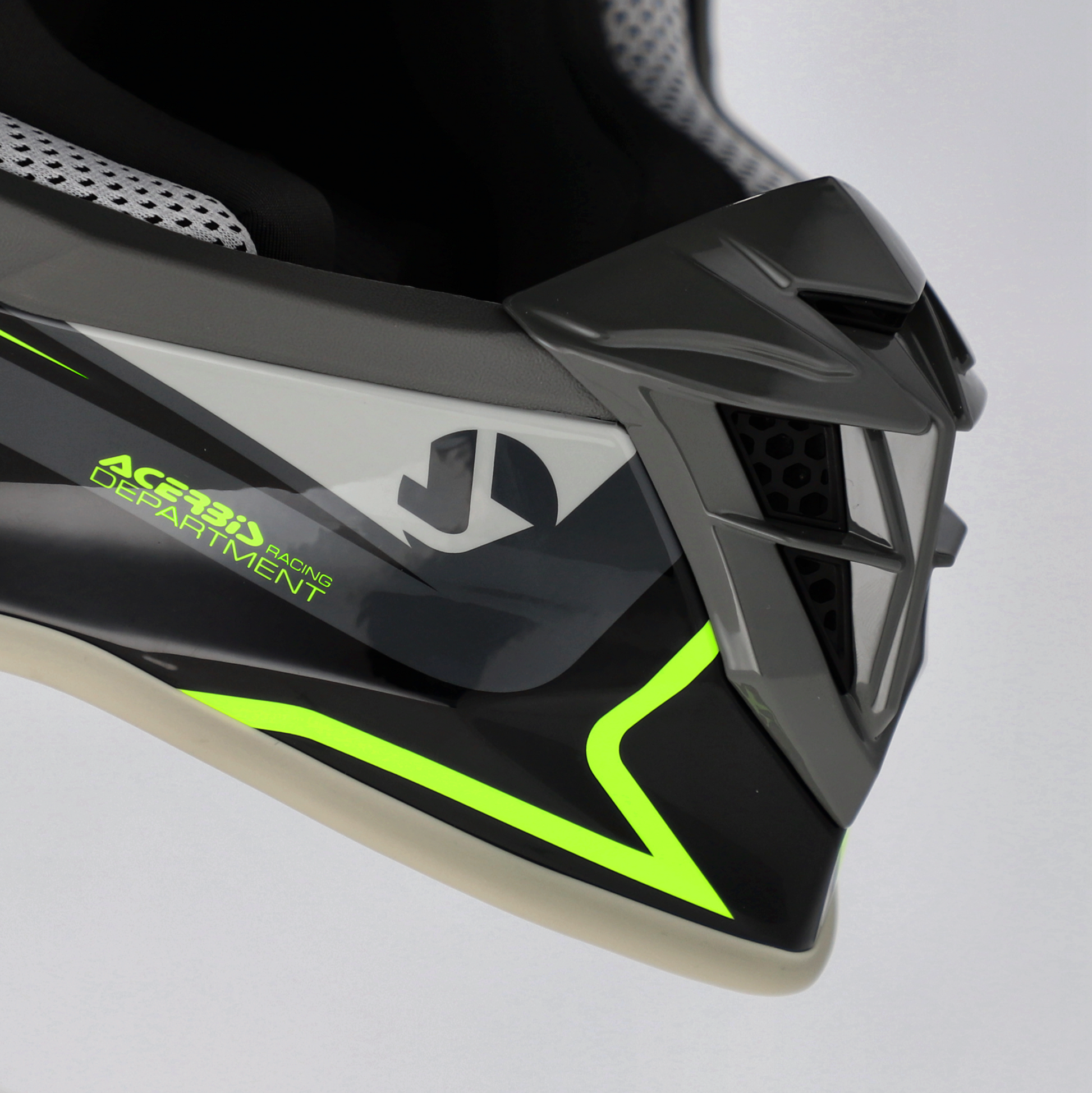 Close-up of a black and green helmet with visible branding on a gray background