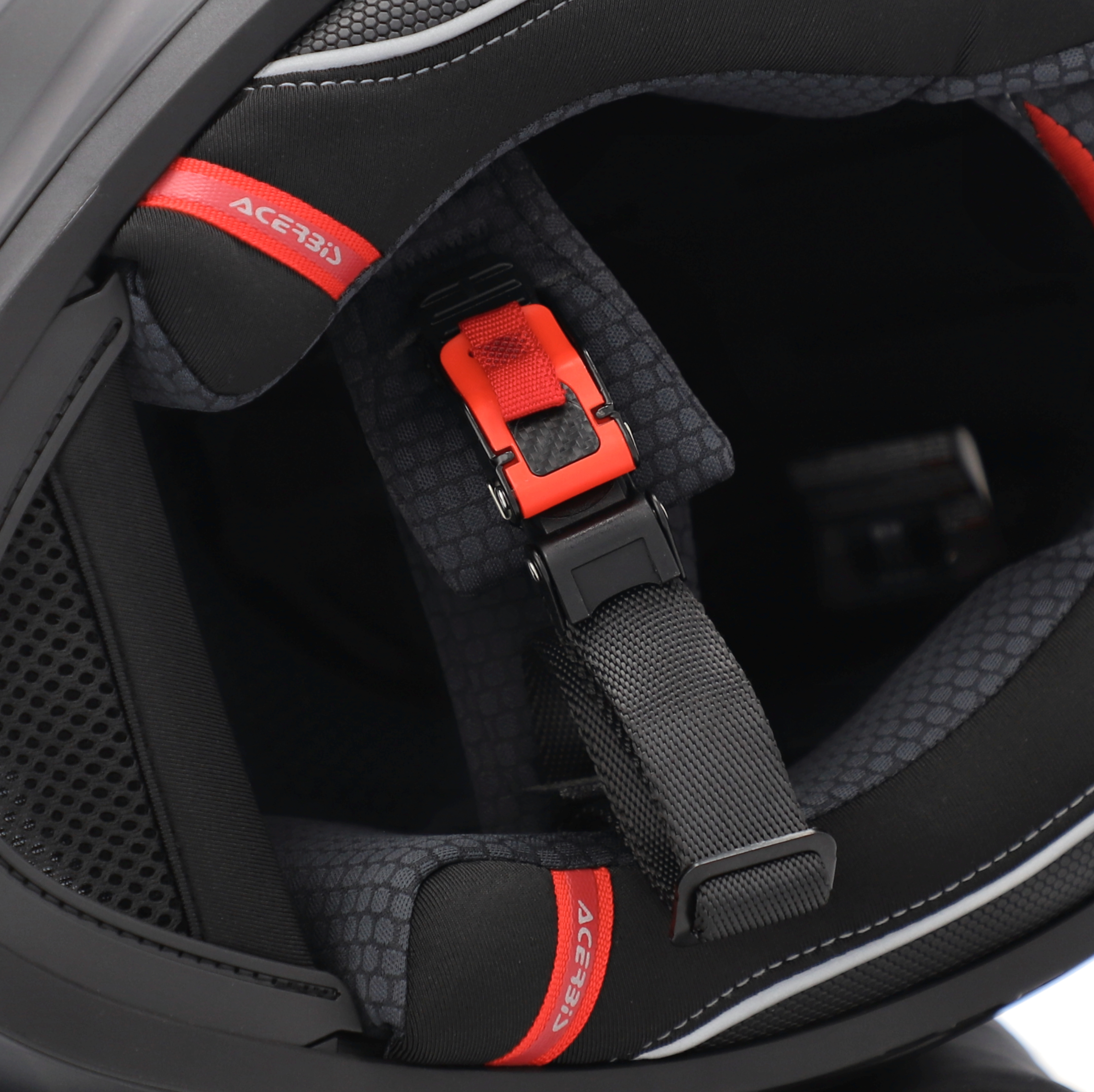Close-up of a black and red Acerbis motorcycle helmet with chin strap.