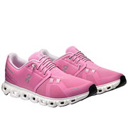 Pink running shoes with white soles on a gray background