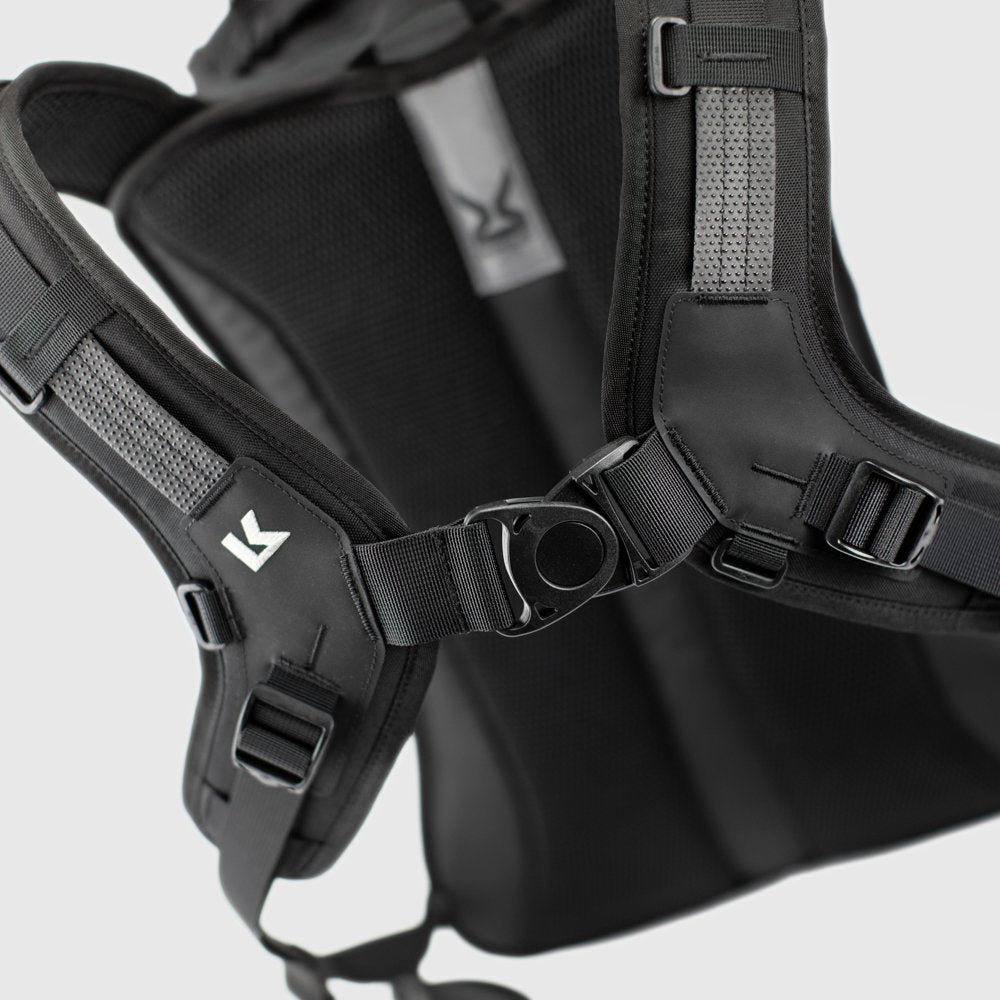 Close-up of a black backpack with straps on a light gray background